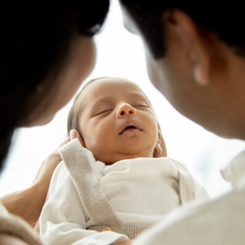 A close-up photograph of a newborn baby sleeping peacefully.