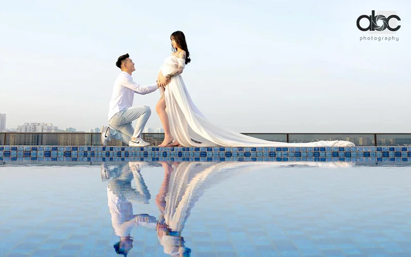 Man kneeling, woman in white gown, maternity photoshoot Singapore by abc photography