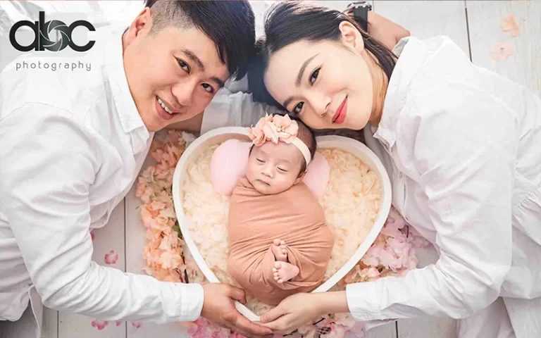 A couple having a photoshoot with their newborn baby