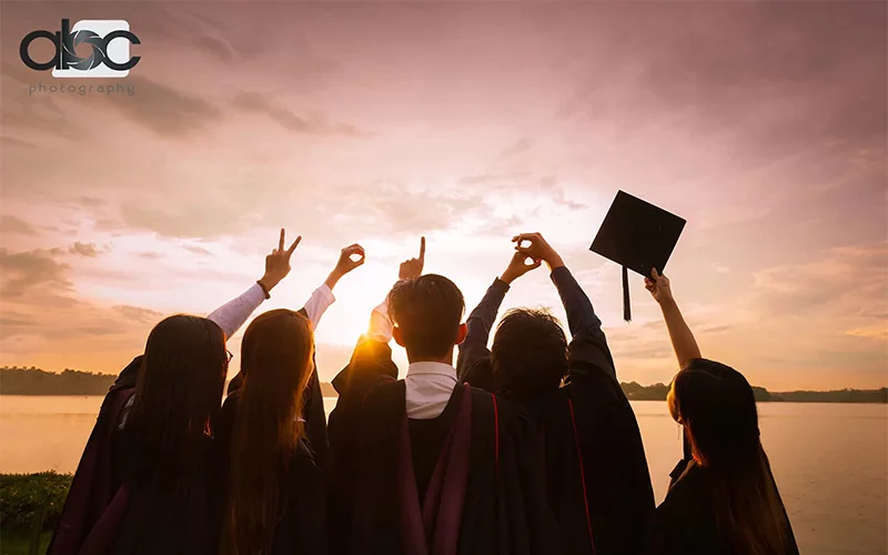 Students gazing at the sky in their graduation gowns