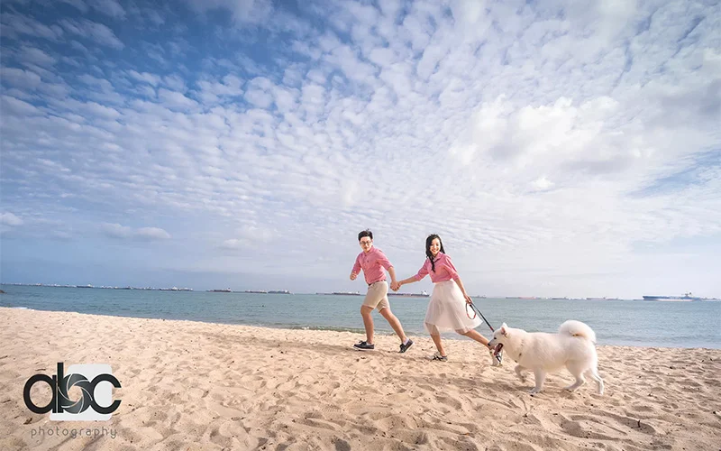 Outdoor family portraits playing in beach with dog