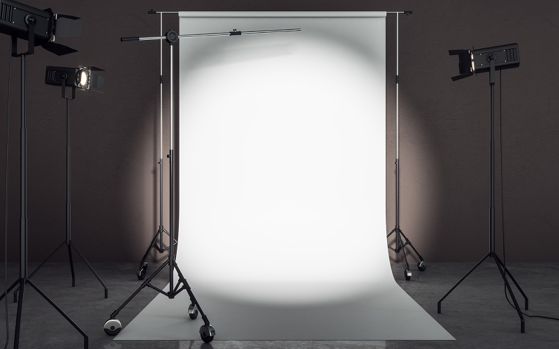 White seamless paper backdrop with studio lighting setup.