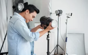 Person adjusting studio light in photography setup