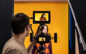 Photographer capturing natural portrait poses in a professional studio.