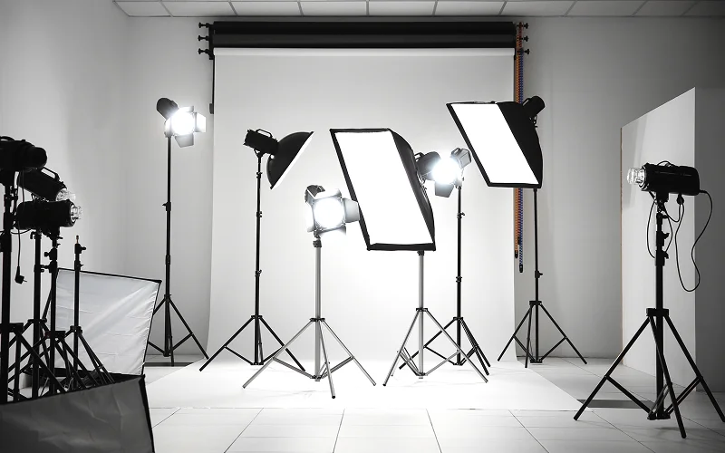 Professional photography studio with various softboxes and white backdrop.