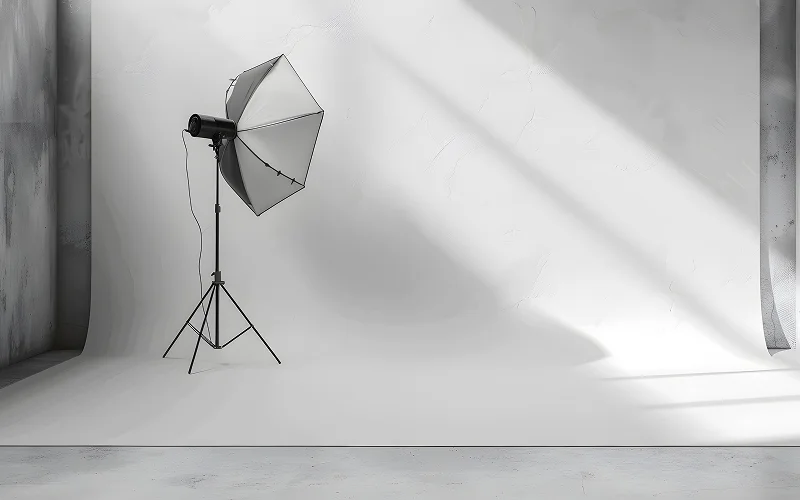 Single studio light with umbrella reflector on white background.