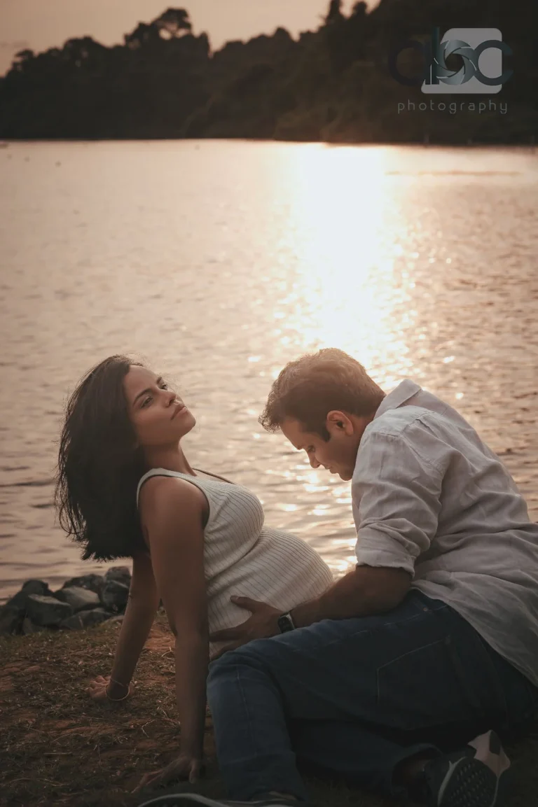 Couple pregnancy photoshoot by lake sunset