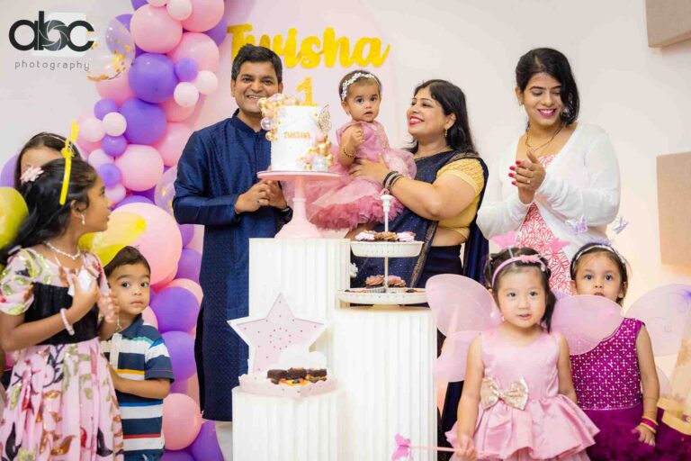 Family celebrating child's first birthday cake