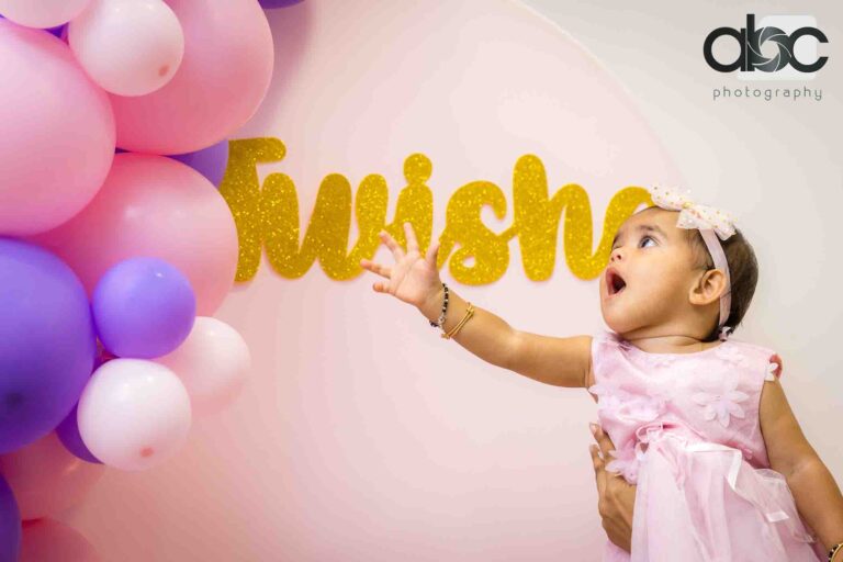 Birthday girl reaching for balloons