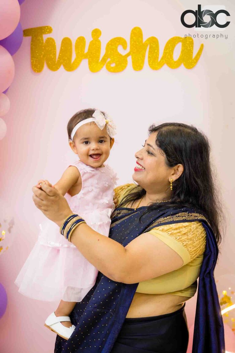 Mother holding baby at birthday photoshoot