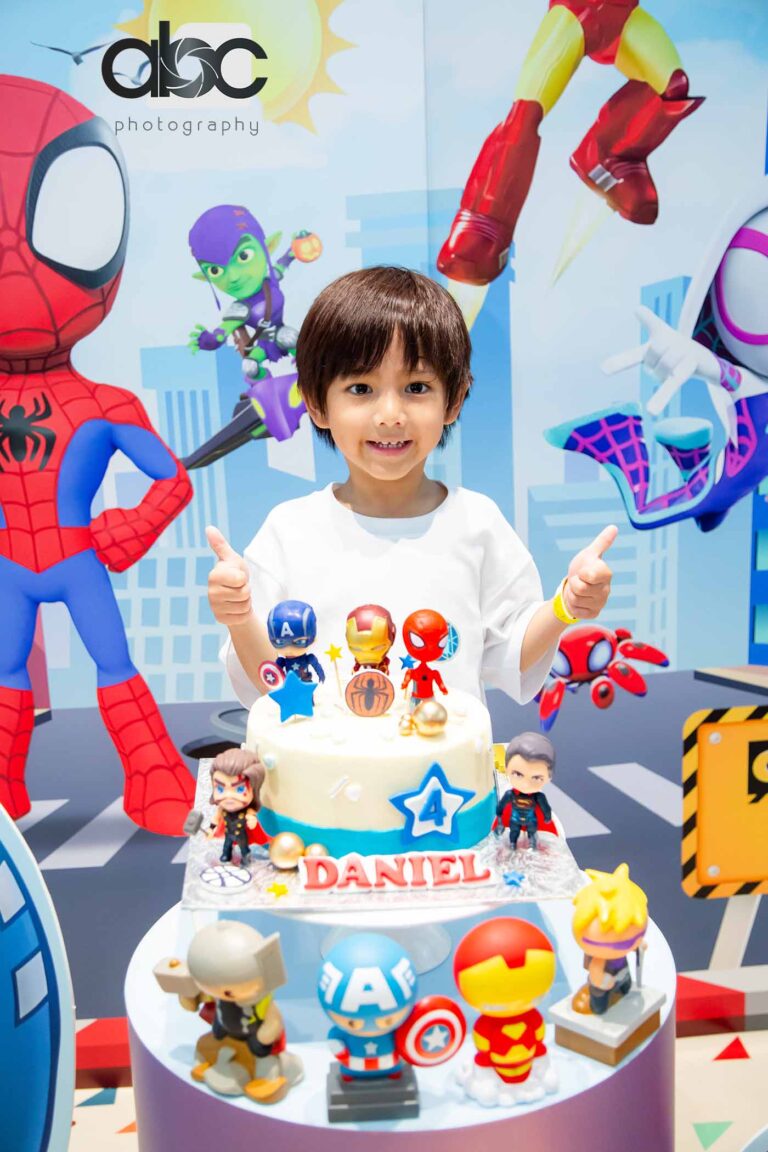 Boy with superhero birthday cake