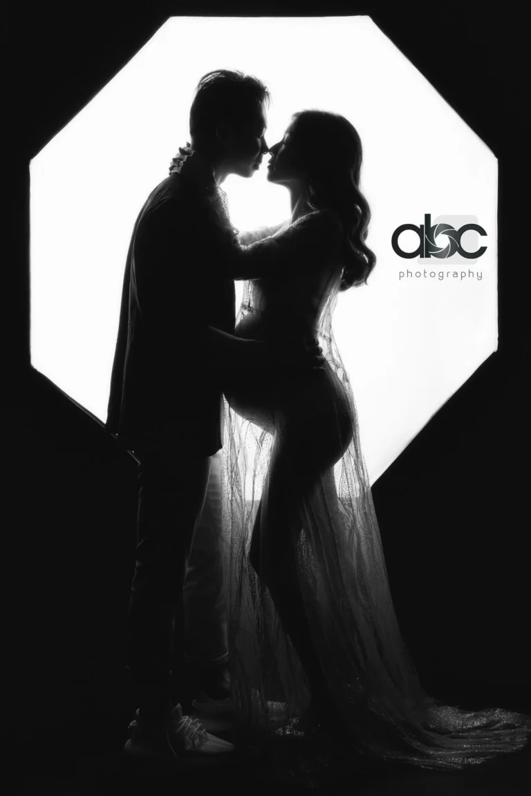 Maternity silhouette couple kissing in studio