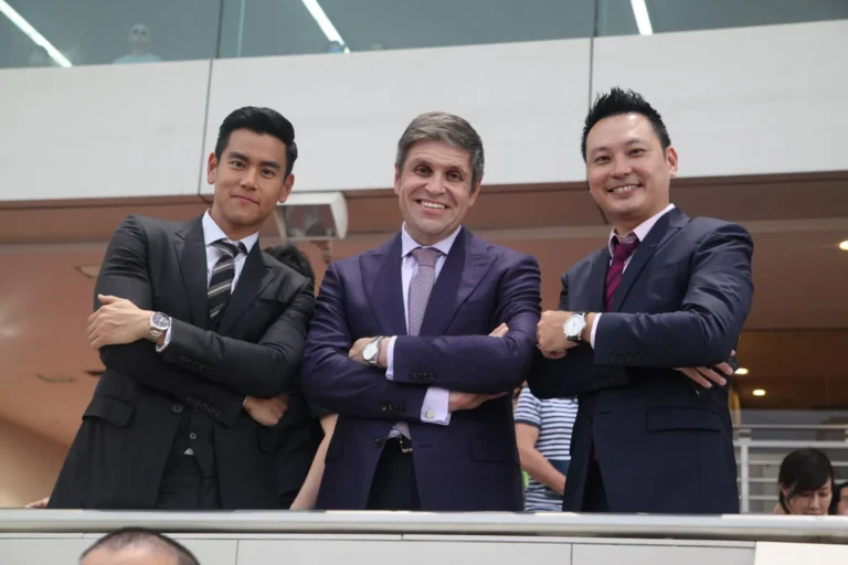 Three businessmen posing at corporate event