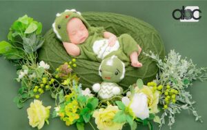 Newborn baby in dinosaur costume for a themed photography session.