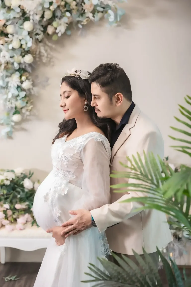 Couple maternity portrait with floral backdrop