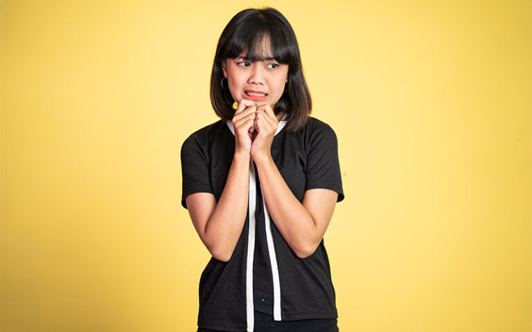 Person camera shy in a yellow background.