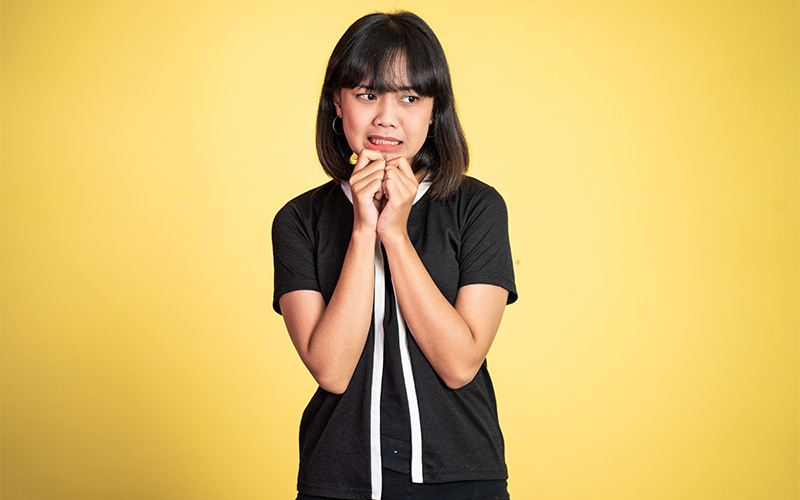 Person camera shy in a yellow background.